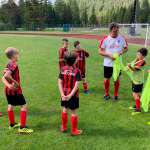 Stefano Eranio with eight children on playing field of the AC Milan Academy Camp