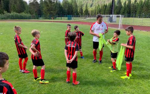 Stefano Eranio with eight children on the AC Milan Junior Camp playing field