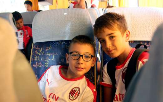 Duas crianças do AC Milan Academy Camp no ônibus que as transporta para o campo de jogos