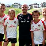 Un componente dello Staff Sporteventi con con tre ragazzi ed una ragazza durante la giornata al Milan Junior Camp