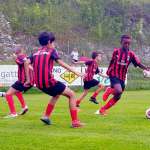 Jogadores jovens (três contra dois) durante o treinamento tático no acampamento de futebol de verão do AC Milan
