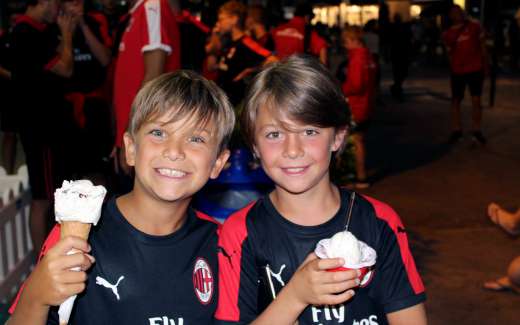 Due bambini mangiano il gelato durante le vacanze estive dell'AC Milan