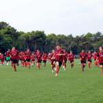 The children of the AC Milan Junior Camp run on the football field of Lignano