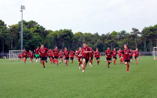 Boys run on the Lignano football field during the AC Milan Junior Camp
