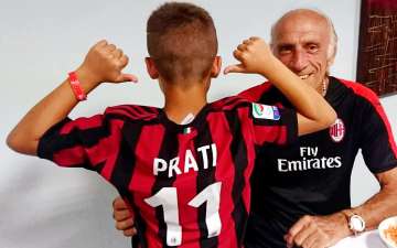 Pierino Prati, former footballer and coach at Milan Junior Camp, with a child wearing his jersey with the number 11 of AC Milan