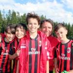 Former footballer Stefano Eranio embraces four kids he trains during AC Milan summer football school