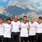 O treinador Walter De Vecchi junto com sete meninos do AC Milan Camp com as Dolomitas de Cortina d'Ampezzo ao fundo
