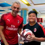 Diego Bortoluzzi, supervisor do AC Milan, no refeitório da vila turística do AC Milan Academy Camp em Lignano Sabbiadoro, dá uma bola para um japonês