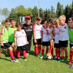 The supervisor Diego Bortulizzi with eleven children of the AC Milan Academy Camp at the playing field of Jesolo (Venice)