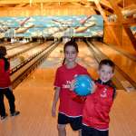 Drei Kinder des AC Milan Academy Camps spielen Bowling während des Sommercamps in Asiago