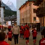 Les enfants passent le long du Corso Italia à Cortina d'Ampezzo accompagnés du personnel de l'AC Milan Academy Junior Camp