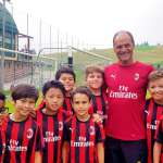 El entrenador Walter De Vecchi con ocho hijos del AC Milan Academy Camp en el campo de juego de Gallio en la meseta de Asiago