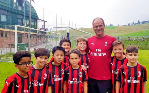 The coach Walter De Vecchi with eight children of the AC Milan Academy Camp at the playing field in Gallio on the Asiago plateau