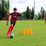 Quattro ragazzi si allenano nel dribbling durante l'AC Milan Junior Camp di Jesolo (Venezia)