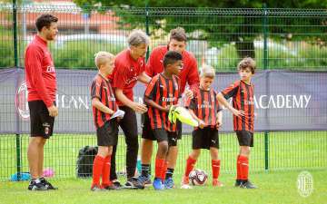 Lorenzo Cresta e due tecnici dello staff di Sporteventi impartiscono le indacazioni a quattro bambini dell'AC Milan Junior Camp