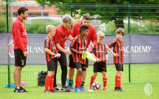 Lorenzo Cresta e due tecnici dello staff di Sporteventi impartiscono le indacazioni a quattro bambini dell'AC Milan Junior Camp