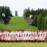 Jovens jogadores do AC Milan Camp em campo em frente ao Trampolim Olímpico de Cortina d'Ampezzo