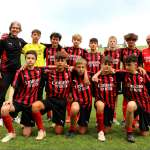 Der Trainer Pietro Vierchowod und der technische Direktor Lorenzo Cresta mit elf Jungs des AC Milan Soccer Camps auf dem Spielfeld von Gallio auf der Hochebene von Asiago