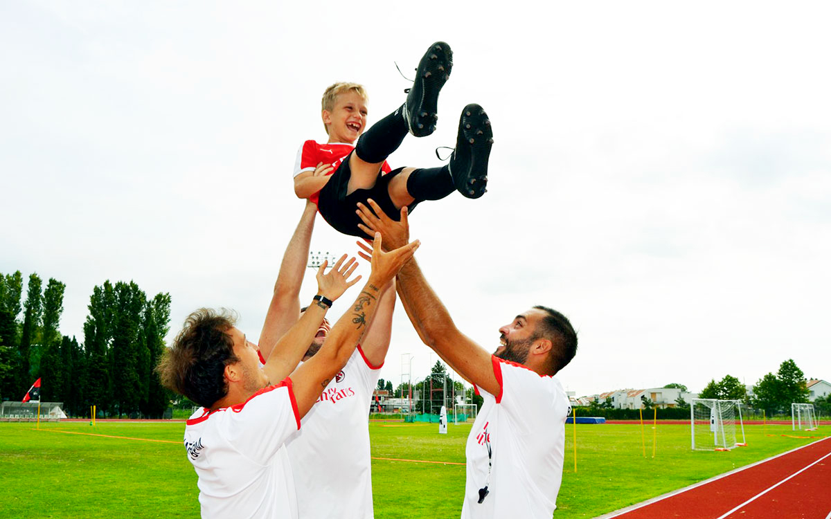 Bambino felice con lo staff di Sporteventi agli AC Milan Junior Camp