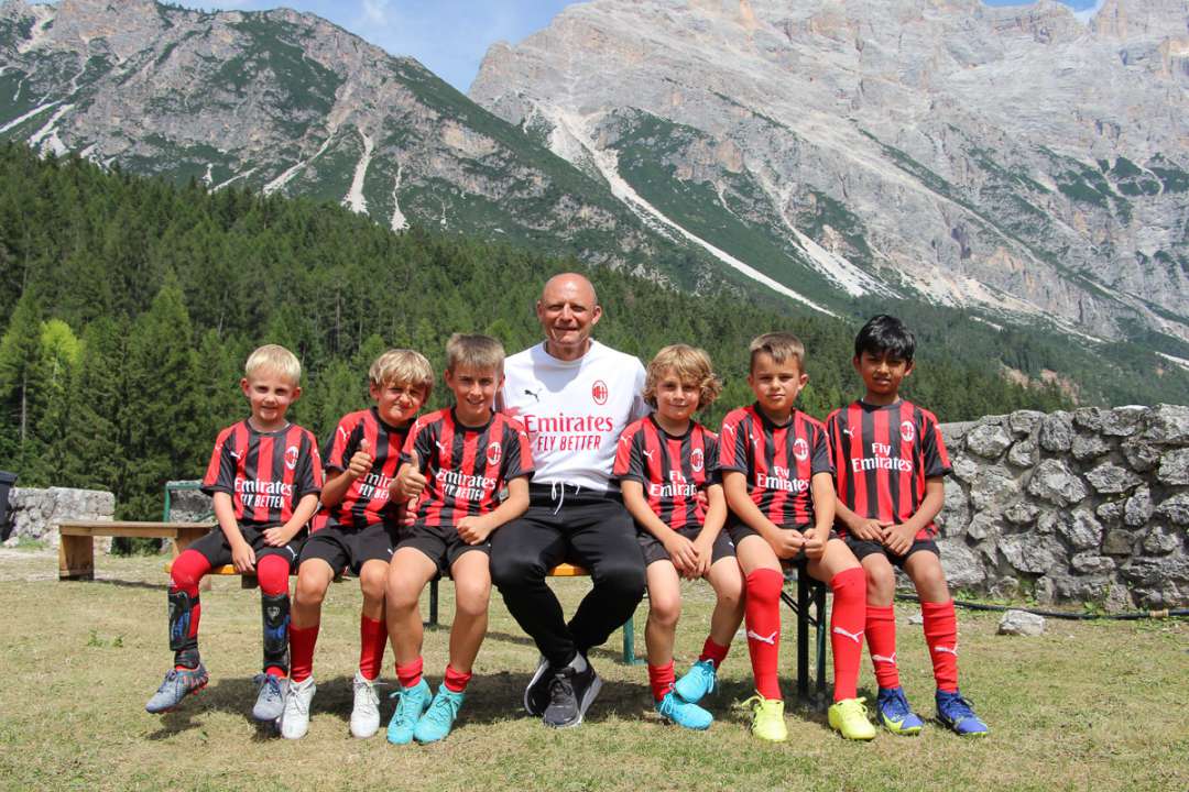 Pietro Vierchowod seduto con sei bambini dell'AC Milan Junior Camp a Cortina D'Ampezzo sulle Dolomiti