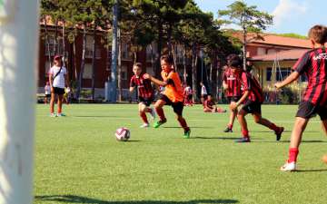 Five children engaged in a football action during training in the AC Milan Academy Camp
